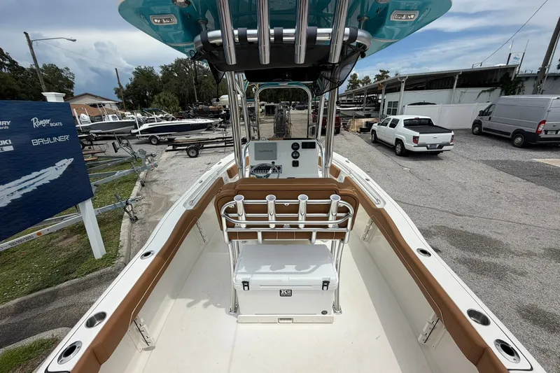 Slide: The Image of 2025 Key West 219 FS boat interior with console and seating, parked in a marina. - 2