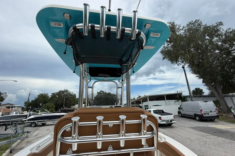 Slide: The Image of 2025 Key West 219 FS boat with blue T-top and rod holders, parked outdoors. - 28