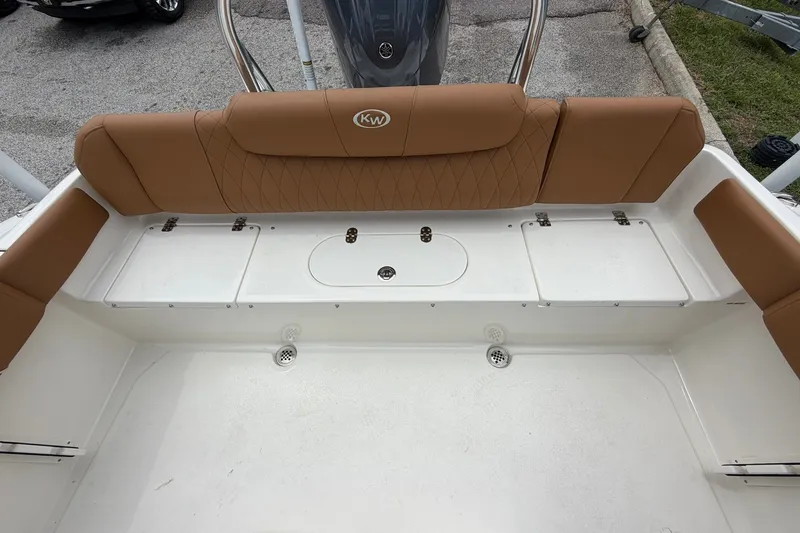 Slide: The Image of 2025 Key West 219 FS boat interior with tan seating and storage compartments. - 7