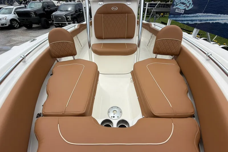 Slide: The Image of 2025 Key West 219 FS boat interior with brown cushioned seating and cup holders. - 11