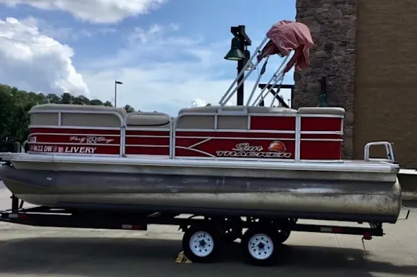 The Image of 2016 Sun Tracker Party Barge 20 DLX pontoon boat on trailer, red and white design. - 0
