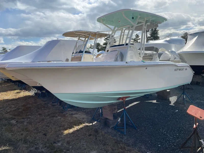 The Image of 2024 Key West 219 FS on a stand, featuring a white hull and turquoise underbody. - 0
