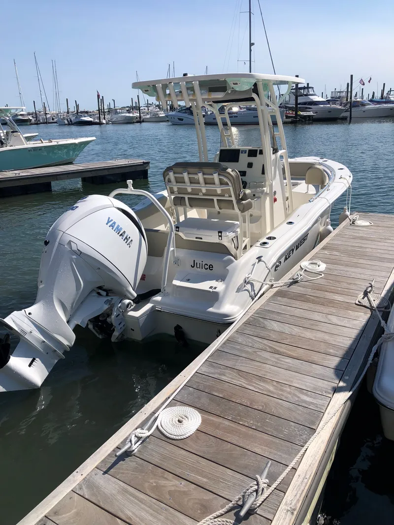 Slide: The Image of A 2024 Key West 219 FS boat docked. It features a Yamaha outboard motor. - 2
