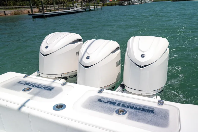 Slide: The Image of Triple Yamaha outboard engines on 2025 Contender 39 ST boat in water. - 16