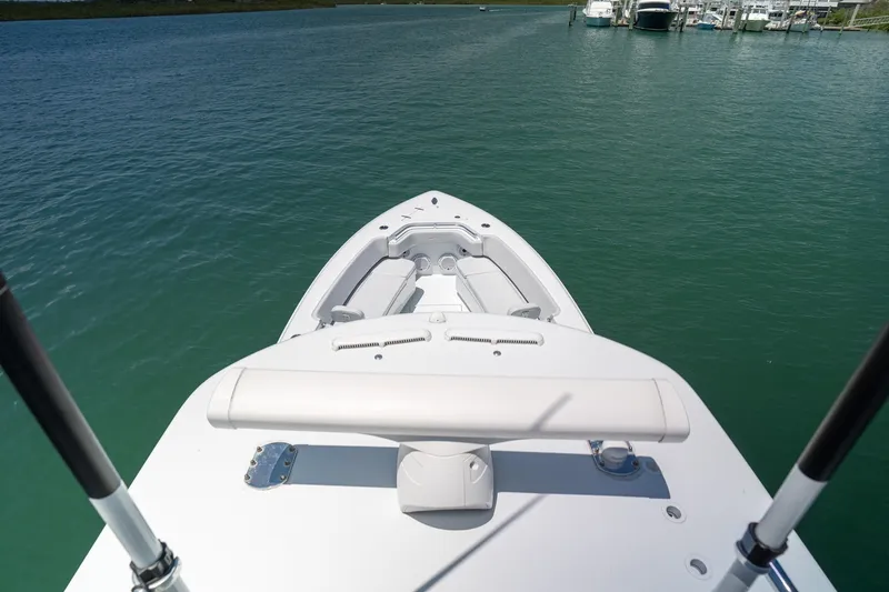 Slide: The Image of Bow view of 2025 Contender 39 ST boat on calm water near a marina. - 23