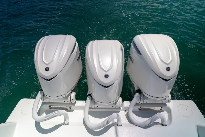 Slide: The Image of Triple Yamaha outboard engines on a 2025 Contender 39 ST boat in clear water. - 24