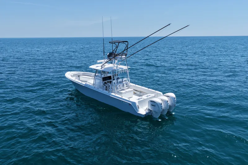 Slide: The Image of 2025 Contender 39 ST boat on open ocean, equipped with dual outboard engines. - 1