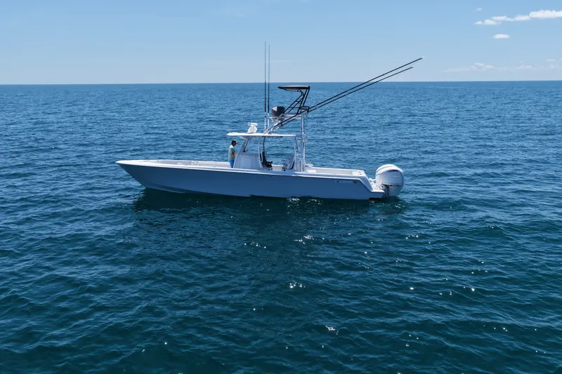 Slide: The Image of 2025 Contender 39 ST boat on open ocean under clear blue sky. - 2