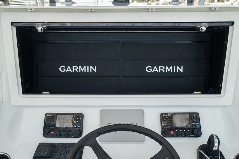 Slide: The Image of 2025 Contender 39 ST boat dashboard with Garmin navigation displays and controls. - 26