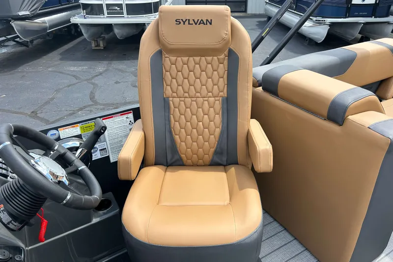 Slide: The Image of Captain's chair of 2027 Sylvan X3 LZ DH Tritoon, featuring tan and gray upholstery. - 11