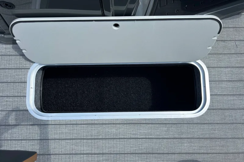 Slide: The Image of Open storage compartment on 2027 Sylvan X3 LZ DH Tritoon boat deck. - 16