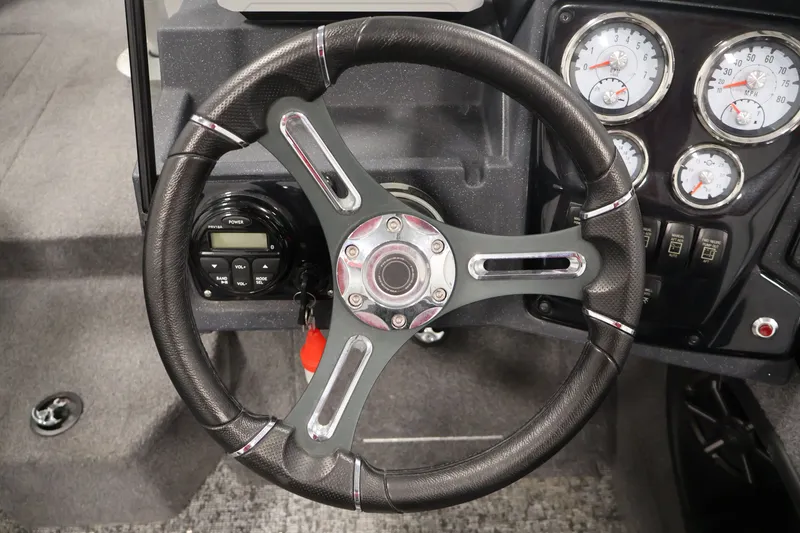 Slide: The Image of Steering wheel and dashboard of 2025 Tracker Targa 18 WT boat, featuring gauges and controls. - 24