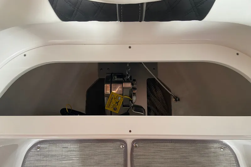 Slide: The Image of 2027 Monterey Elite 25 OB boat storage compartment with visible equipment and wiring. - 15