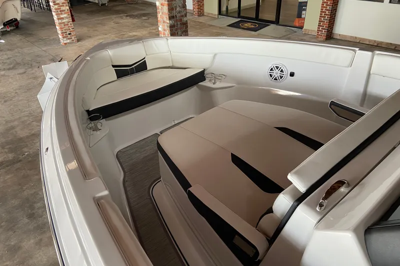 Slide: The Image of 2027 Monterey Elite 25 OB boat interior with cushioned seating and cup holders. - 14