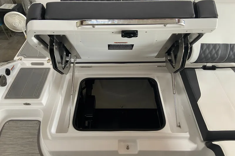 Slide: The Image of Open storage compartment on 2027 Monterey Elite 25 OB boat with cushioned seating. - 6