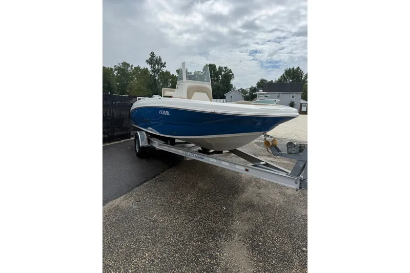 The Image of 2019 Stingray 206 CC boat on trailer, parked outdoors under cloudy sky. - 1