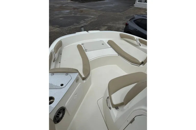 Slide: The Image of 2019 Stingray 206 CC boat interior with beige seating and storage compartments. - 7