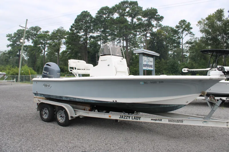 Slide: The Image of 2018 Sea Hunt BX21 boat on trailer, parked outdoors near trees. - 1