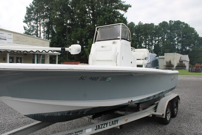 Slide: The Image of 2018 Sea Hunt BX21 boat on trailer, parked outdoors near trees and buildings. - 4