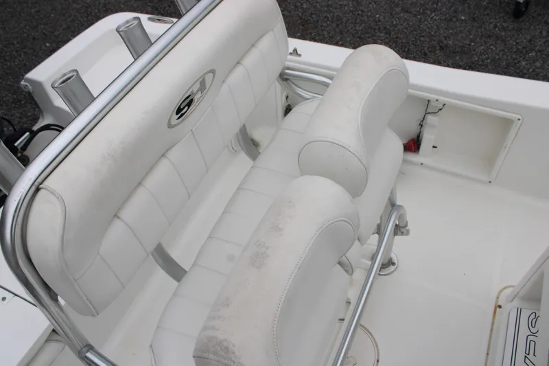 Slide: The Image of 2018 Sea Hunt BX21 boat interior with white cushioned seating and rod holders. - 12