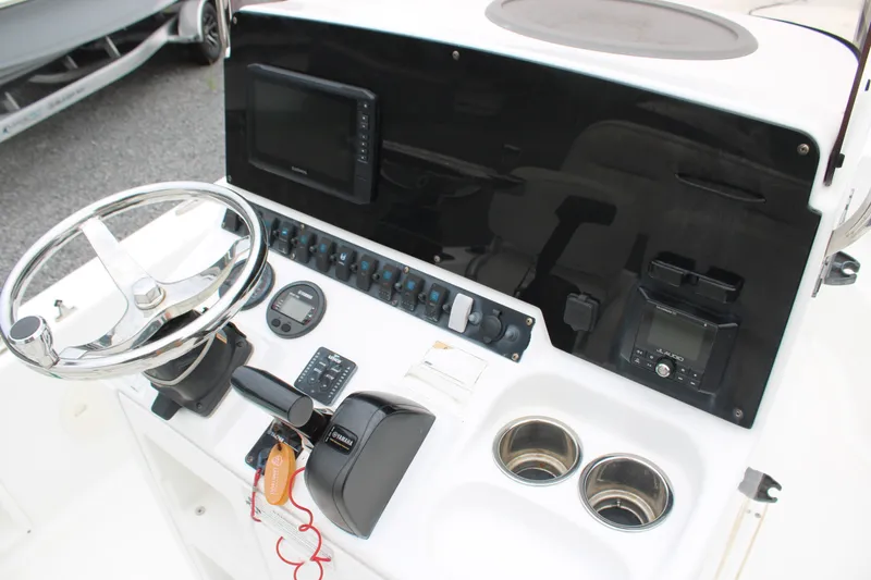 Slide: The Image of 2018 Sea Hunt BX21 boat console with steering wheel, controls, and electronic displays. - 13