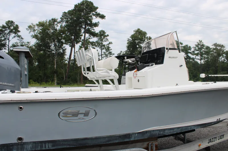 Slide: The Image of 2018 Sea Hunt BX21 boat on trailer, side view with trees in background. - 10