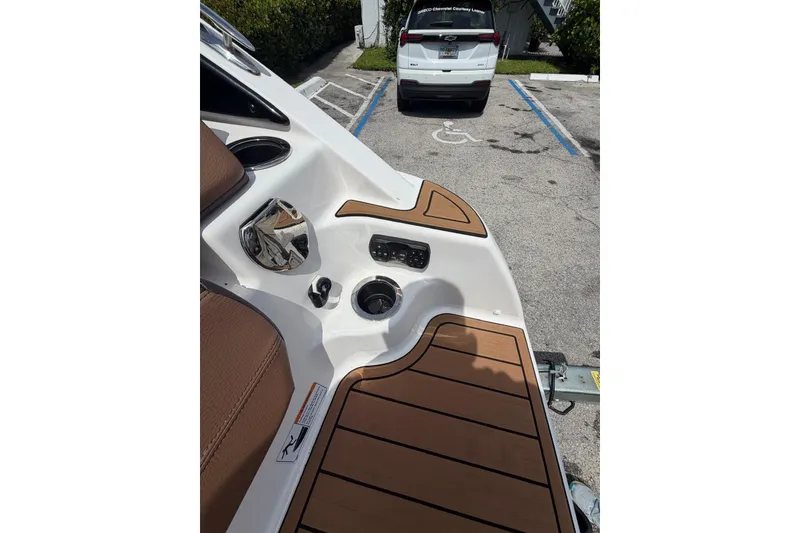 Slide: The Image of 2025 Yamaha 252 SD boat interior with brown seating and cup holders. - 16