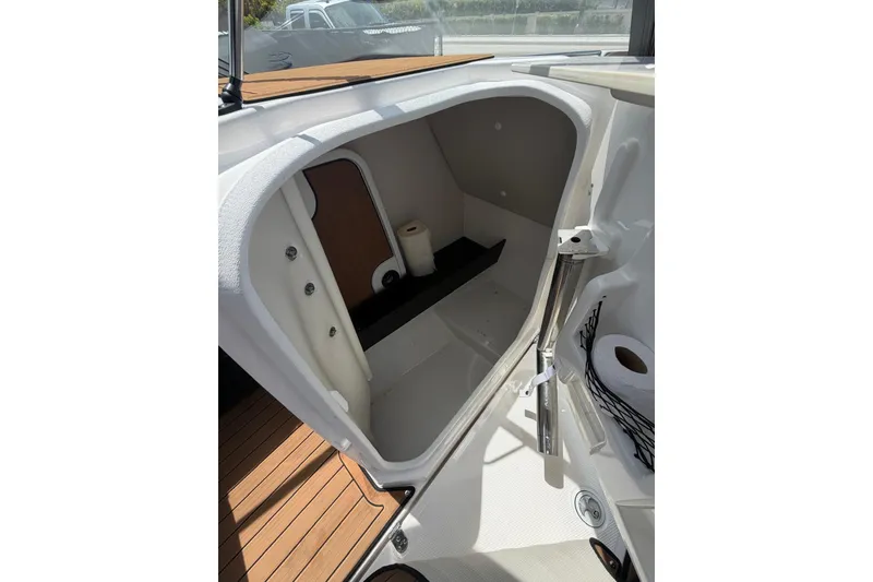 Slide: The Image of 2025 Yamaha 252 SD boat interior storage compartment with wooden flooring and accessories. - 17