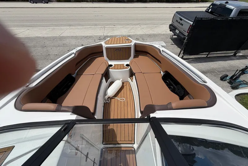 Slide: The Image of 2025 Yamaha 252 SD boat interior with brown seating and wood accents. - 18