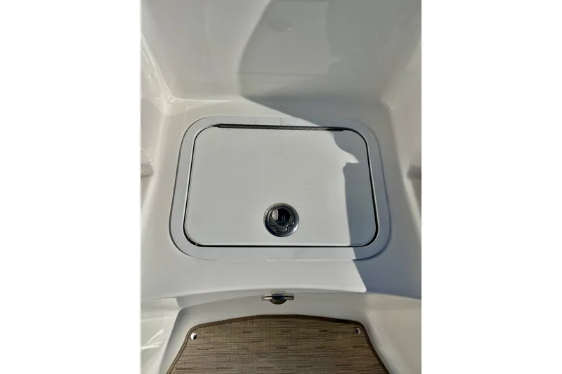 Slide: The Image of 2013 Hurricane SunDeck 2200 OB boat storage compartment with latch, white interior. - 51