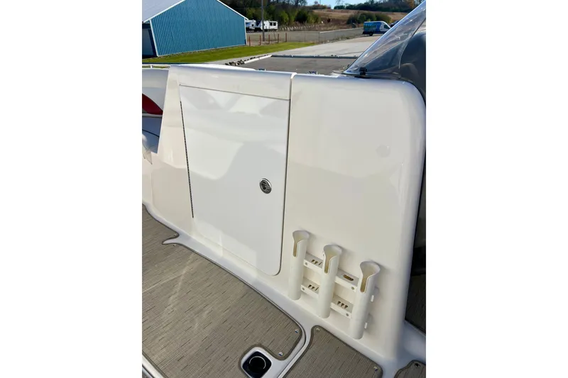 Slide: The Image of 2013 Hurricane SunDeck 2200 OB boat interior with rod holders and storage compartment. - 35