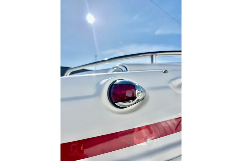 Slide: The Image of 2013 Hurricane SunDeck 2200 OB boat detail with red navigation light under clear sky. - 68