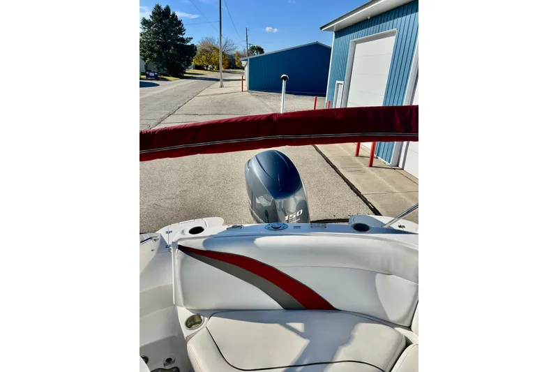 Slide: The Image of 2013 Hurricane SunDeck 2200 OB boat with Yamaha 150 engine, parked near blue building. - 64