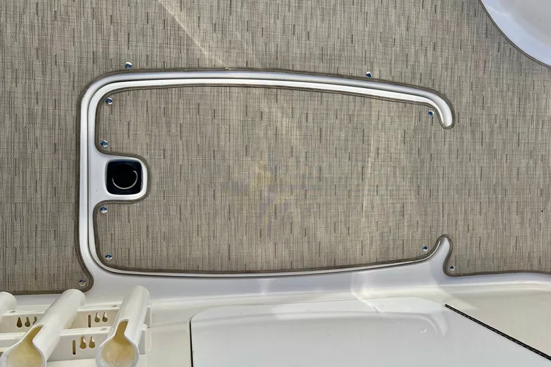 Slide: The Image of 2013 Hurricane SunDeck 2200 OB boat deck with storage compartment and rod holders. - 58