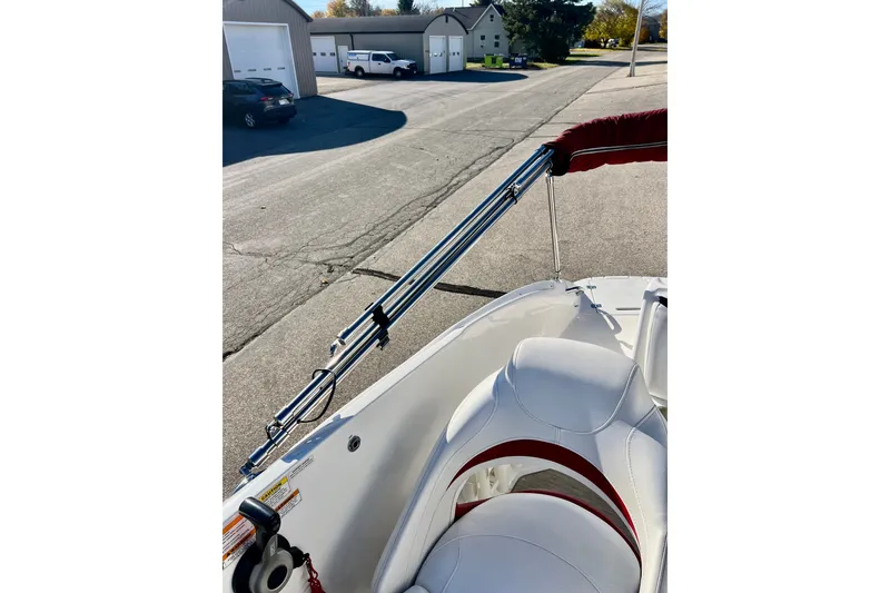 Slide: The Image of 2013 Hurricane SunDeck 2200 OB boat with white seating and red accents, parked near garages. - 62