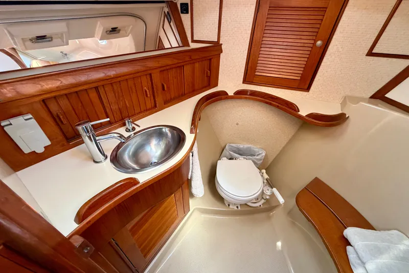 Slide: The Image of 1995 Island Packet 40 yacht bathroom with wooden cabinetry, stainless steel sink, and marine toilet. - 40