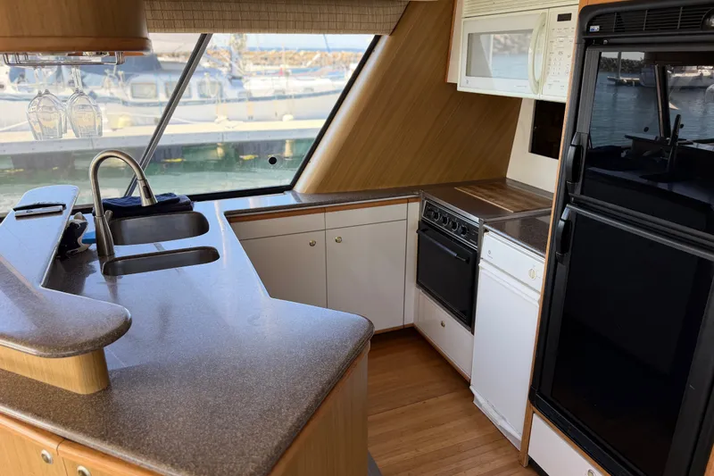 Slide: The Image of Interior of 2000 Bayliner 4788 Pilot House Motoryacht kitchen with modern appliances. - 29