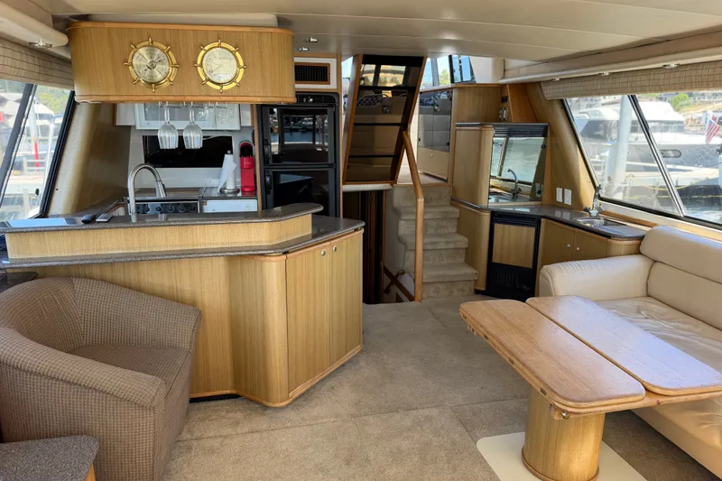 Slide: The Image of Interior of 2000 Bayliner 4788 Pilot House Motoryacht with cozy seating and kitchenette. - 26