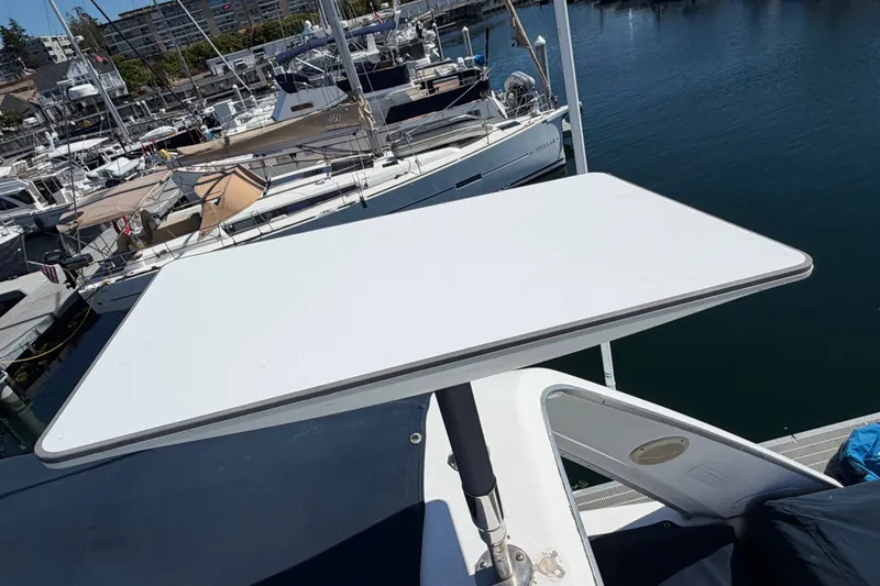 Slide: The Image of Bayliner 4788 Pilot House Motoryacht 2000 with a raised deck table at marina. - 17