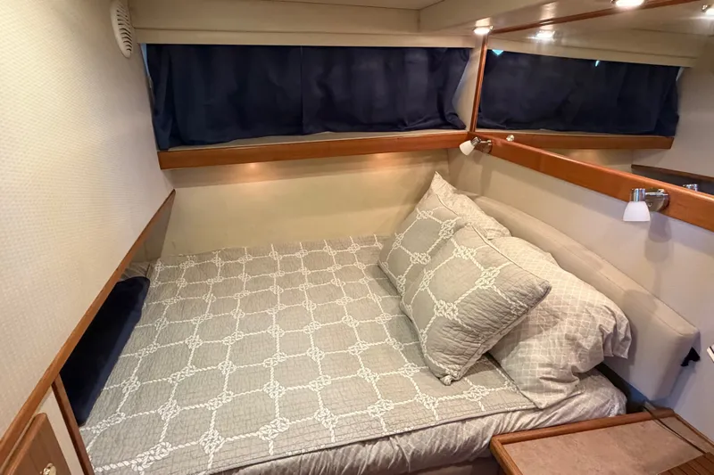 Slide: The Image of Cozy bedroom interior of 2000 Bayliner 4788 Pilot House Motoryacht with elegant bedding. - 40