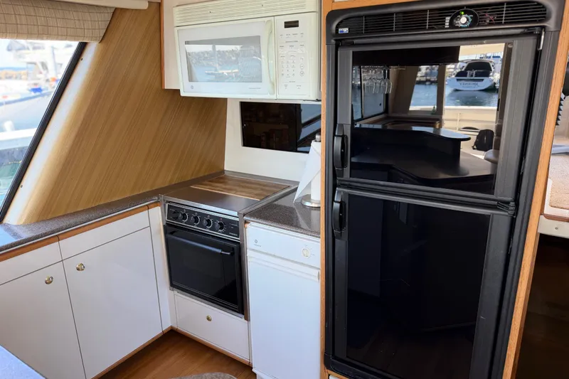 Slide: The Image of Interior kitchen of 2000 Bayliner 4788 Pilot House Motoryacht with appliances and wood accents. - 30