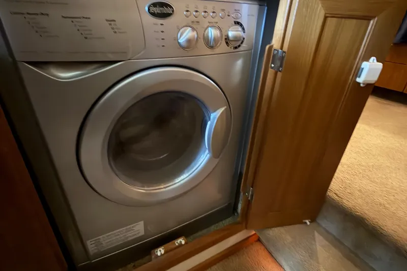 Slide: The Image of Washing machine inside 2000 Bayliner 4788 Pilot House Motoryacht, with wooden cabinet door open. - 45