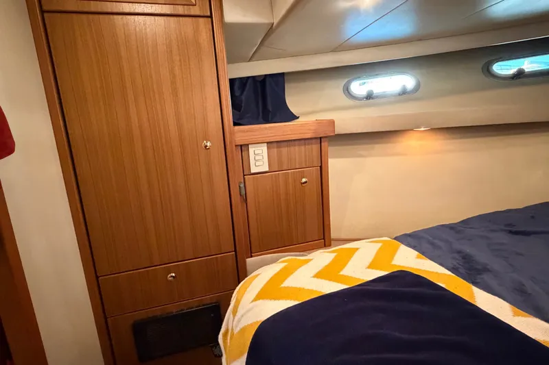 Slide: The Image of Interior cabin of 2000 Bayliner 4788 Pilot House Motoryacht with wood paneling and cozy bedding. - 47