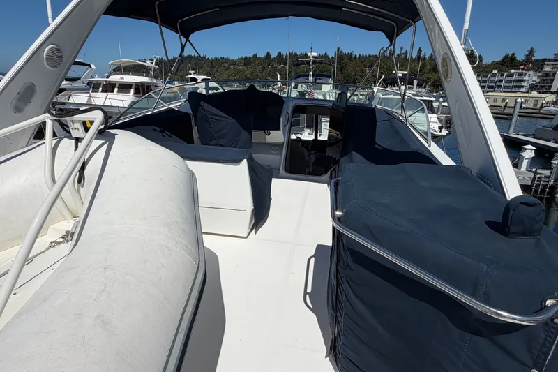 Slide: The Image of 2000 Bayliner 4788 Pilot House Motoryacht with covered seating, docked at marina. - 16