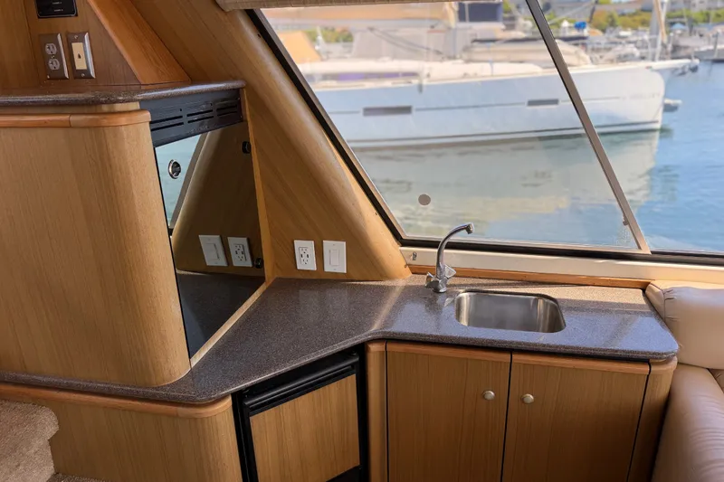 Slide: The Image of Interior of 2000 Bayliner 4788 Pilot House Motoryacht with kitchenette and marina view. - 28