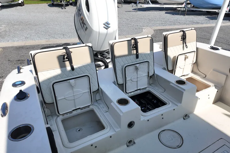 Slide: The Image of 2021 Carolina Skiff 24 Ultra Elite boat with open storage compartments and Suzuki engine. - 19