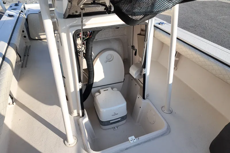 Slide: The Image of 2021 Carolina Skiff 24 Ultra Elite boat interior with portable toilet and storage area. - 9