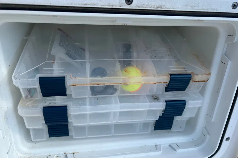 Slide: The Image of Storage compartment with tackle boxes on a 2021 Tidewater 198 CC Adventure boat. - 14