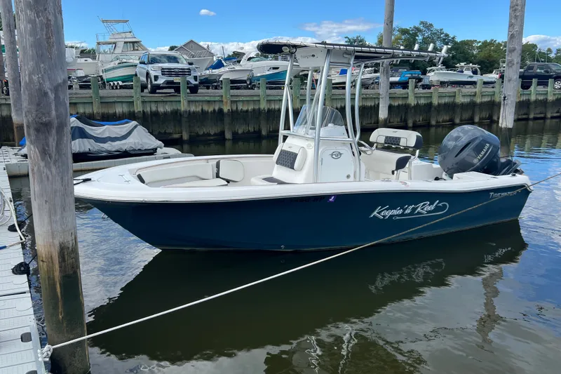 Slide: The Image of 2021 Tidewater 198 CC Adventure boat docked in a marina, featuring a Yamaha outboard motor. - 2