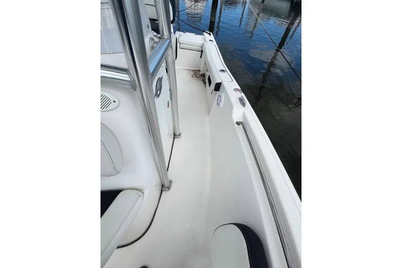 Slide: The Image of 2021 Tidewater 198 CC Adventure boat interior with seating and railing, docked by water. - 6